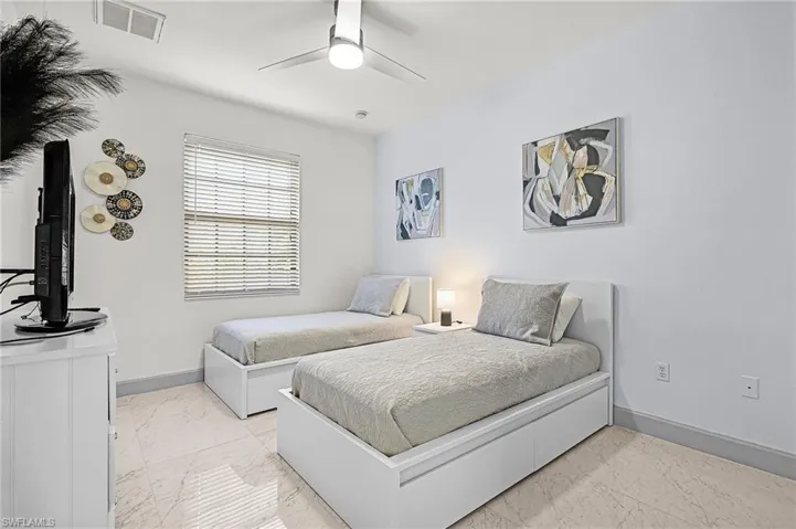 Bedroom with light marble finish floors and a ceiling fan