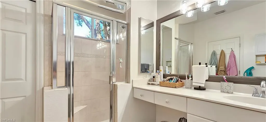 Bathroom featuring visible vents, a shower stall, and vanity