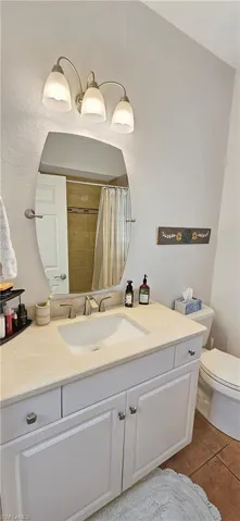 Bathroom with toilet, vanity, and tile patterned flooring