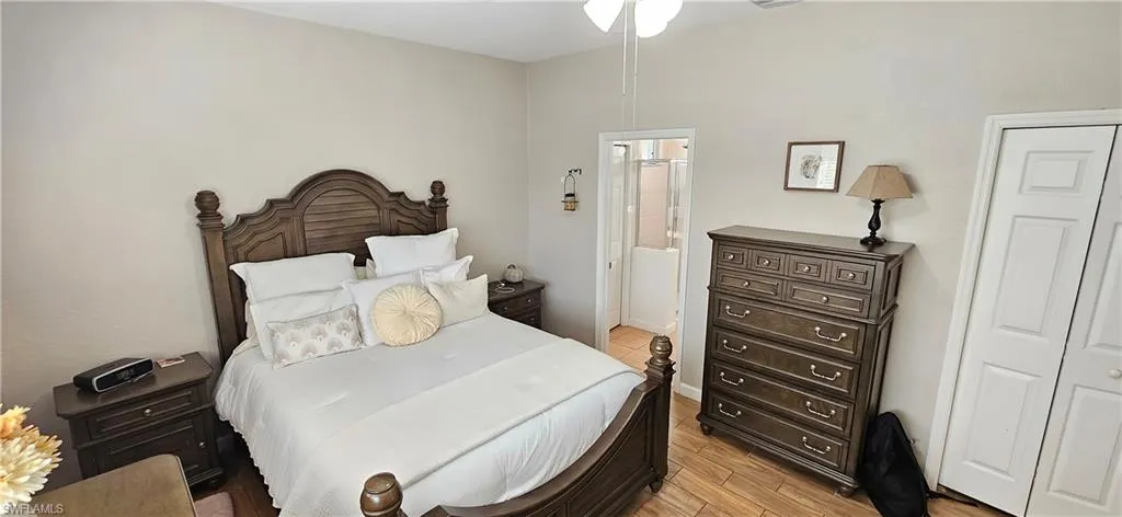 Bedroom with light wood-style flooring and ensuite bath