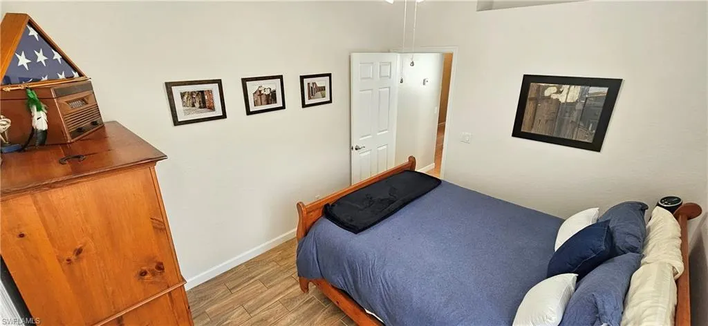 Bedroom with wood finished floors and baseboards