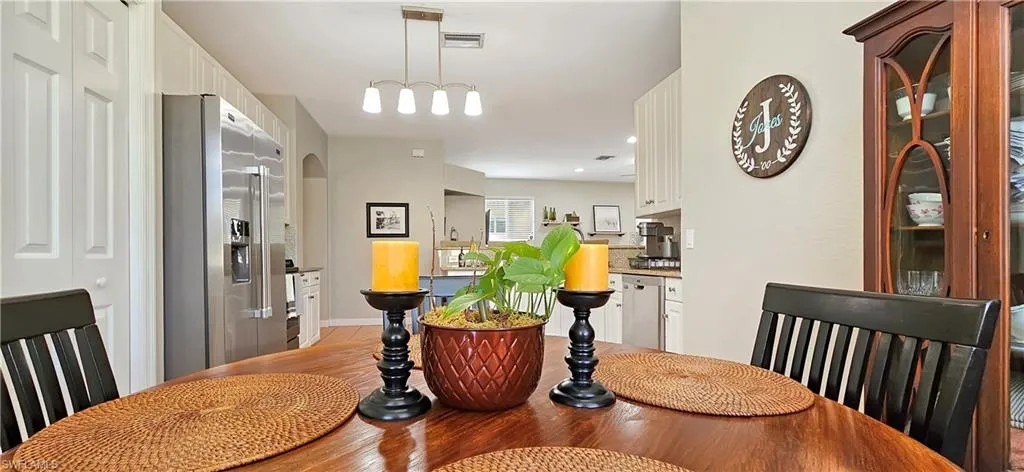 Dining area with arched walkways, visible vents, and light wood-type flooring