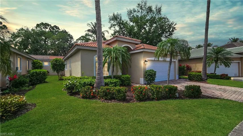 Mediterranean / spanish-style house featuring stucco siding, decorative driveway, an attached garage, a tile roof, and a lawn