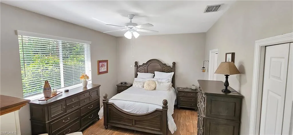 Bedroom featuring visible vents, light wood finished floors, and a ceiling fan
