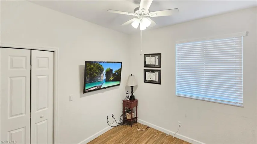 Unfurnished bedroom with light wood-type flooring, a closet, baseboards, and a ceiling fan