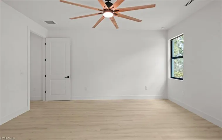 Empty room featuring light wood-style floors and a ceiling fan