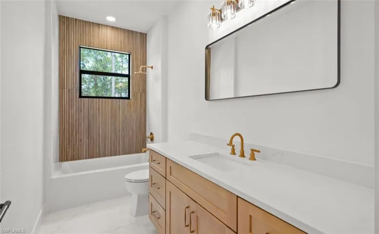 Full bathroom with vanity, bathtub / shower combination, light marble finish flooring, and recessed lighting