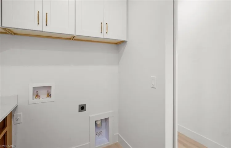 Laundry room with light wood-type flooring, washer hookup, hookup for an electric dryer, and cabinet space