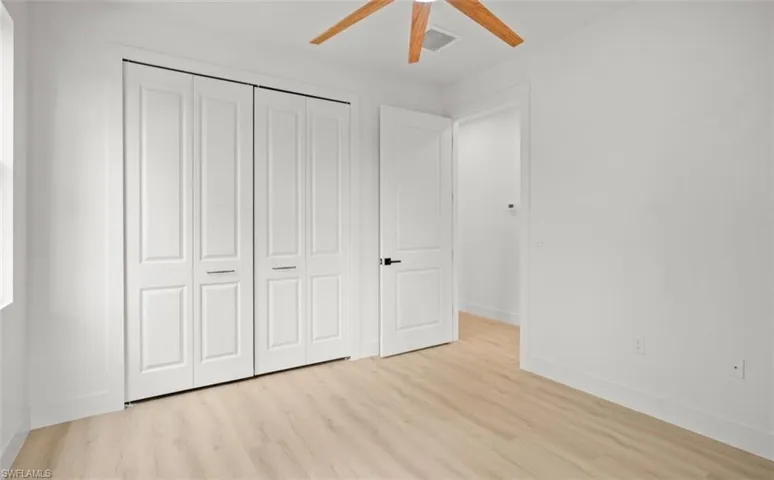 Unfurnished bedroom with light wood-type flooring, a closet, and ceiling fan