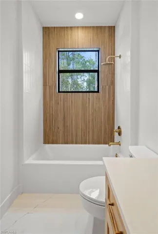 Full bath featuring vanity, shower / bath combination, and tile patterned flooring
