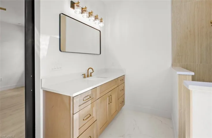 Bathroom featuring vanity and light marble finish floors