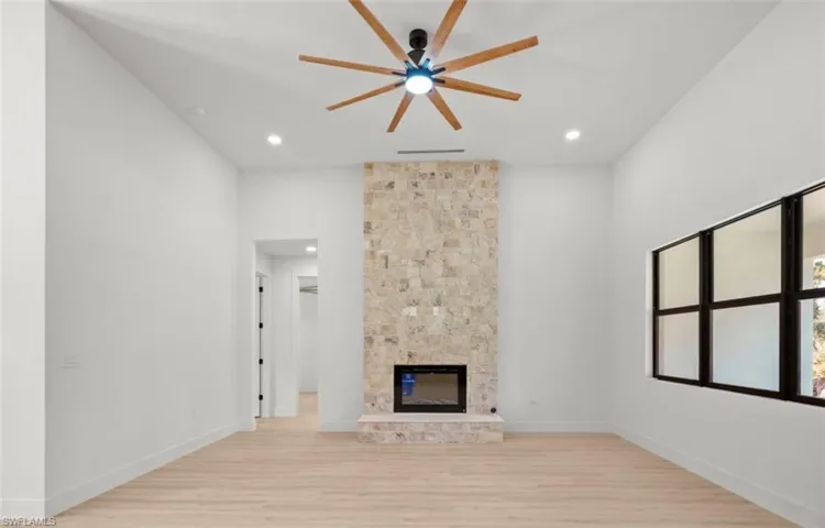 Unfurnished living room with light wood-type flooring, a tile fireplace, a ceiling fan, and recessed lighting