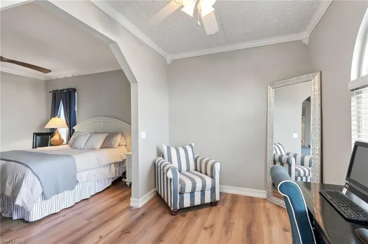 Wood-finish flooring throughout, featuring a recessed arched doorway - Virtually Edited Image
