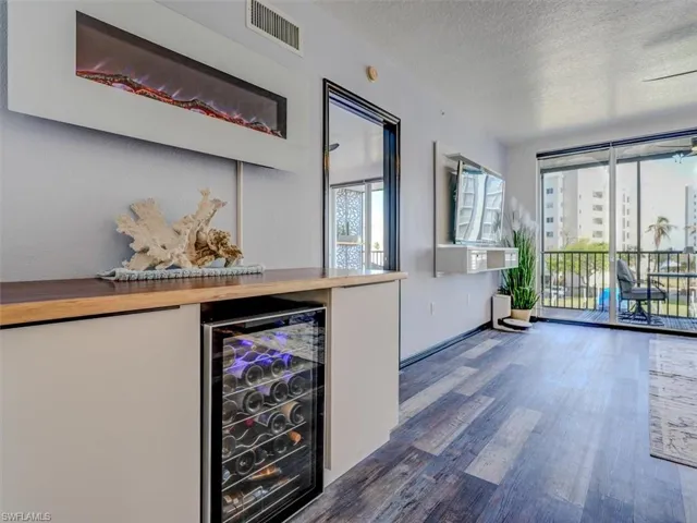 CUSTOM DINING AREA CABINETRY.  BEVERAGE COOLER.  WALL-MOUNTED ELECTRIC FIREPLACE.  ENTRANCE TO OWNER'S SUITE IS SHOWN MIDDLE REAR.