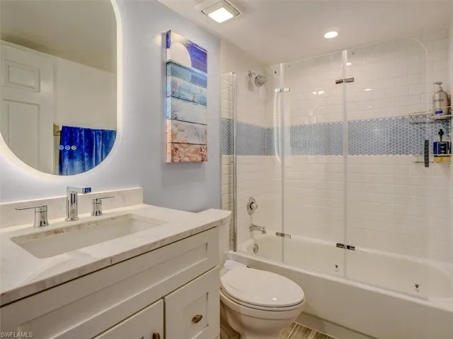 GUEST BATH W/MARBLE-TOPPED VANITY, ANTI-FOG BACKLIT MIRROR.  COMBO TUB/SHOWER W/GLASS DOORS AND FULL-HEIGHT TILED SHOWER WALLS.