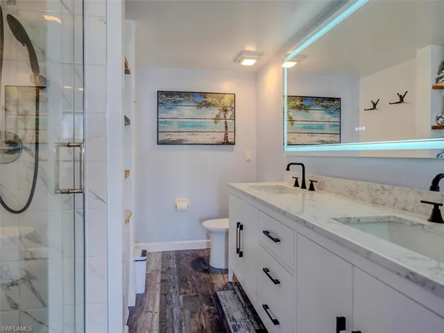 OWNER'S SUITE BATH.  MARBLE-TOPPED DUAL SINK VANITY.  ANTI-FOG BACK-LIT MIRROR.