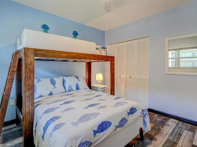Bedroom featuring dark wood-style flooring, ceiling fan, and a closet