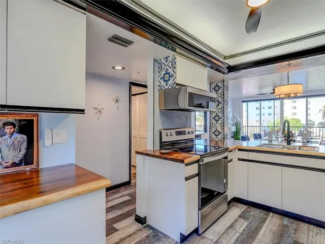 VIEW FROM KITCHEN TOWARDS UNIT ENTRANCE (LEFT).  LOUVERED DOORS HIDE WASHER/DRYER.
