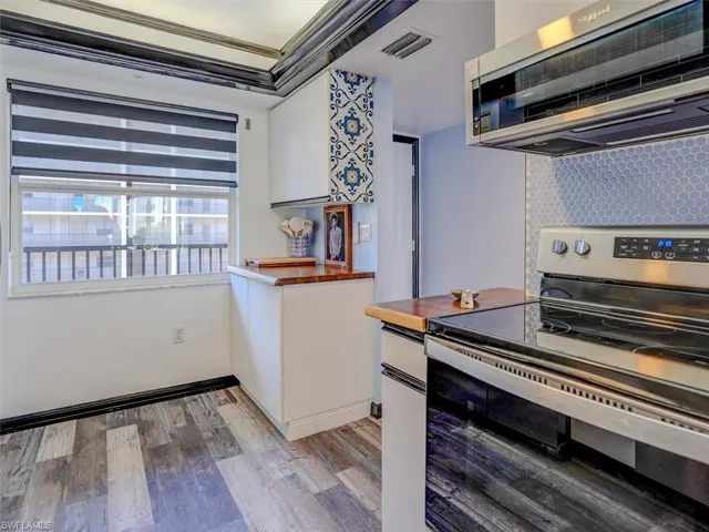 KITCHEN VIEW.  CUSTOM ZEBRA SHADES.  ENTRANCE TO UNIT SHOWN MIDDLE REAR.
