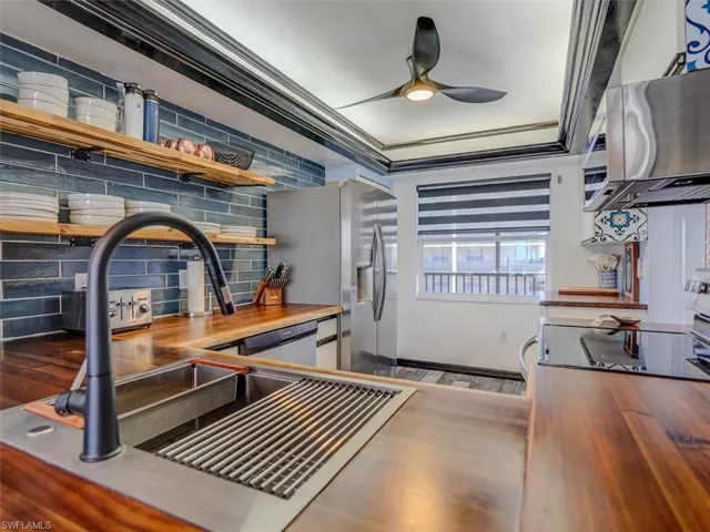KITCHEN FEATURES:  FULL-HEIGHT SUBWAY TILE BACKSPLASH, OPEN SHELVING; ACACIA WOOD COUNTERTOPS; LIGHTED TRAY CEILING; MODERN CEILING FAN W/LIGHT; STAINLESS STEEL SINK W/HIGH ARC FAUCET