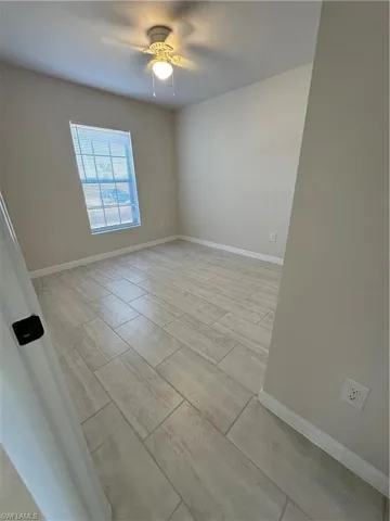 Empty room with wood tiled floors and ceiling fan