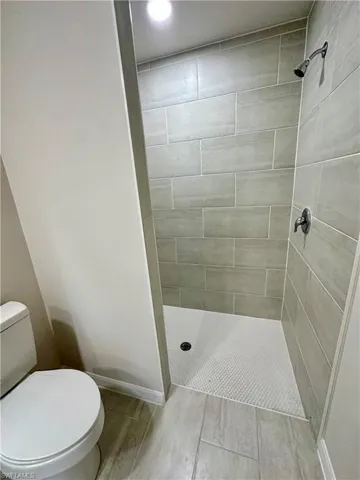 Bathroom featuring a stall shower, recessed lighting, and wood finish floors