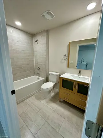 Full bath with vanity, tub / shower combination, and recessed lighting