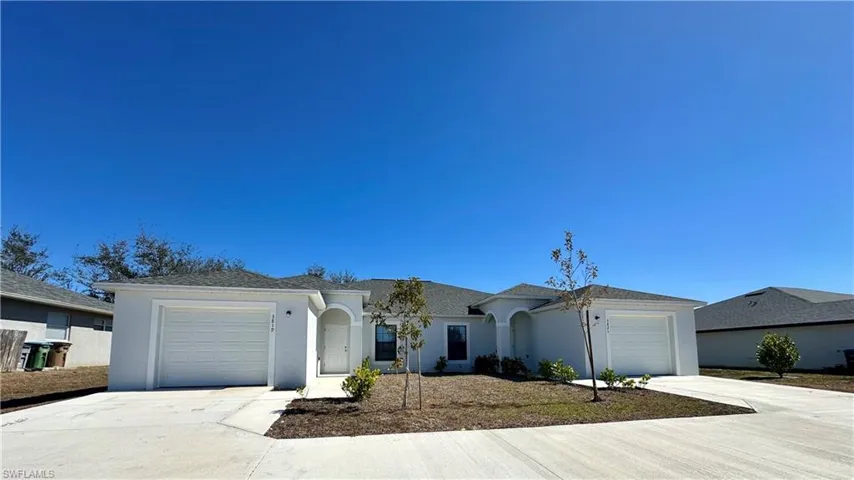 Ranch-style home with a garage, concrete driveway, and stucco siding