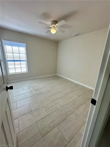 Empty room with wood finish floors and a ceiling fan