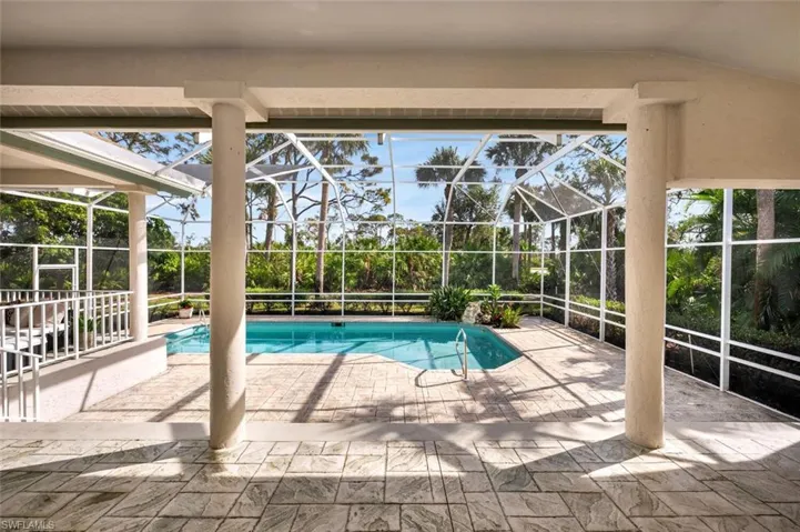 View of pool with a lanai and a patio area