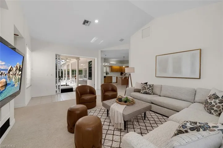 Living room featuring vaulted ceiling and light colored carpet