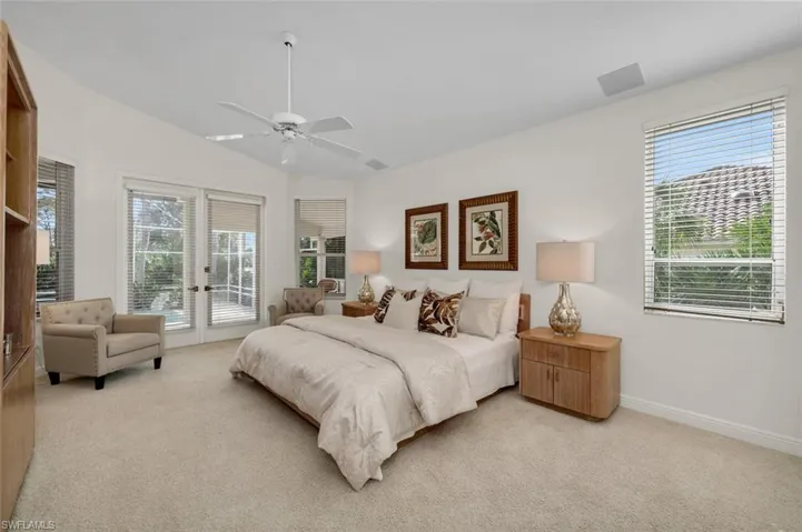 Bedroom featuring light carpet, ceiling fan, access to exterior, french doors, and vaulted ceiling