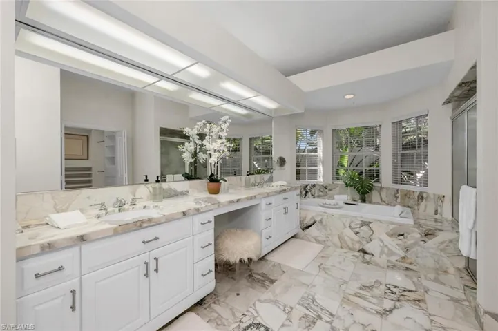 Bathroom featuring tiled bath and vanity