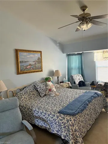 Bedroom featuring a ceiling fan, carpet, and a textured wall