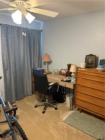Office with ceiling fan and light carpet