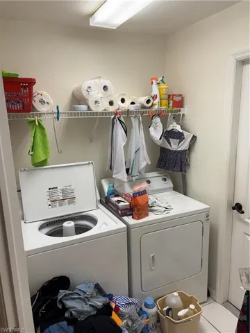 Laundry room with a textured wall and independent washer and dryer
