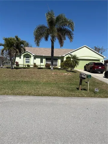 Ranch-style home with an attached garage, a front yard, and concrete driveway