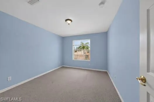 Recessed ceiling light, wall-mounted light fixture, carpeted flooring, and a single window