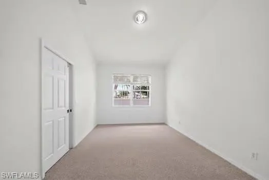 Recessed lighting, neutral wall paint, window with blinds, paneled door, and carpet flooring