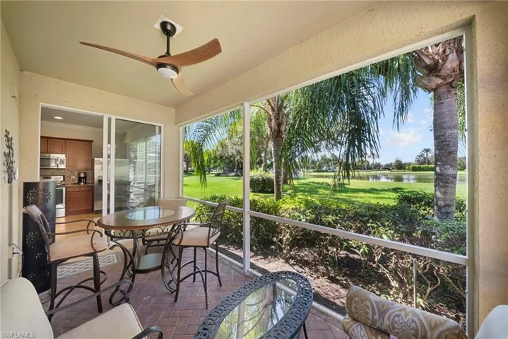 Screened outdoor patio featuring brick paver flooring, a ceiling fan, and sliding glass doors