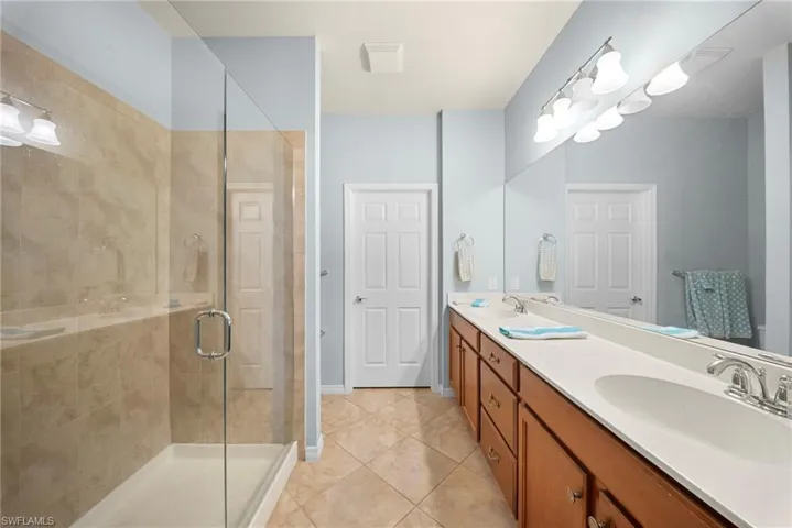 Glass-enclosed shower with tile surround and built-in shelf