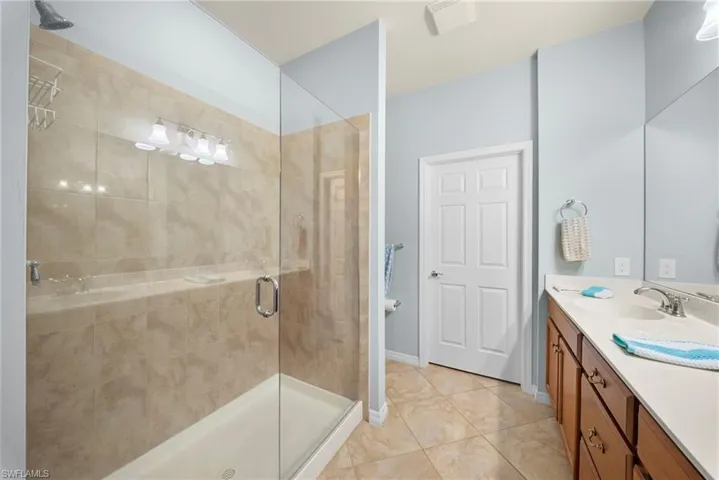 Glass-enclosed shower with tiled walls and a built-in shelf