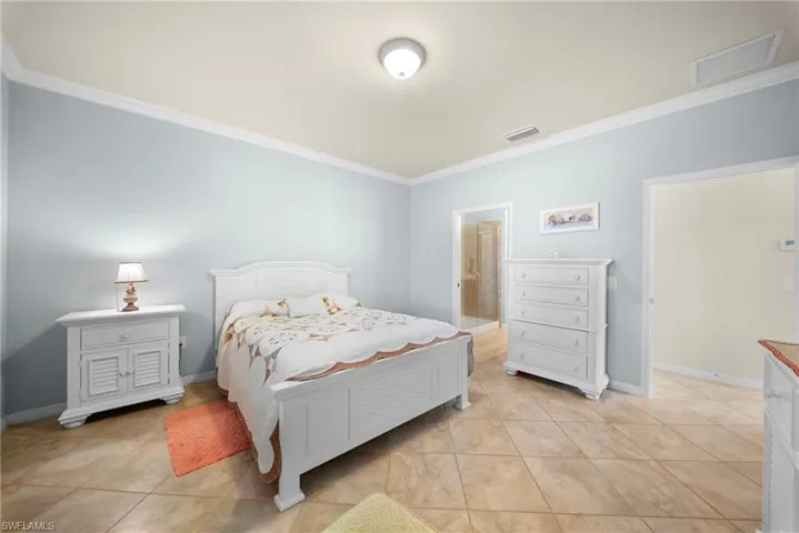Crown molding, recessed ceiling light, tiled flooring, light blue wall paint, and white trim