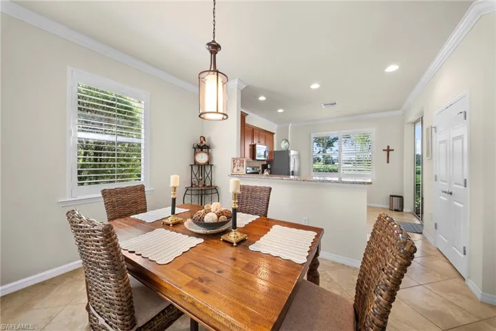 Wood-finish dining table, recessed lighting, crown molding, and tiled flooring