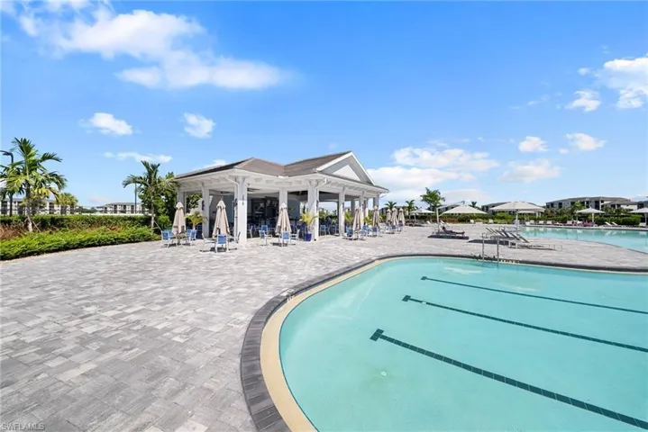 Expansive paver patio with a resort-style swimming pool, complete with lap lanes
