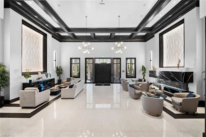 Vaulted coffered ceiling, large format tile flooring, black framed windows, double entry doors, and built-in linear fireplace with stone surround