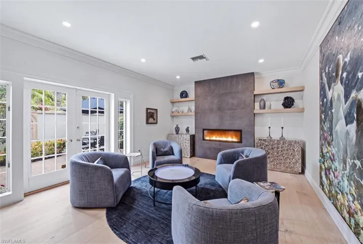 Living room accented by a Fireplace and floating shelves