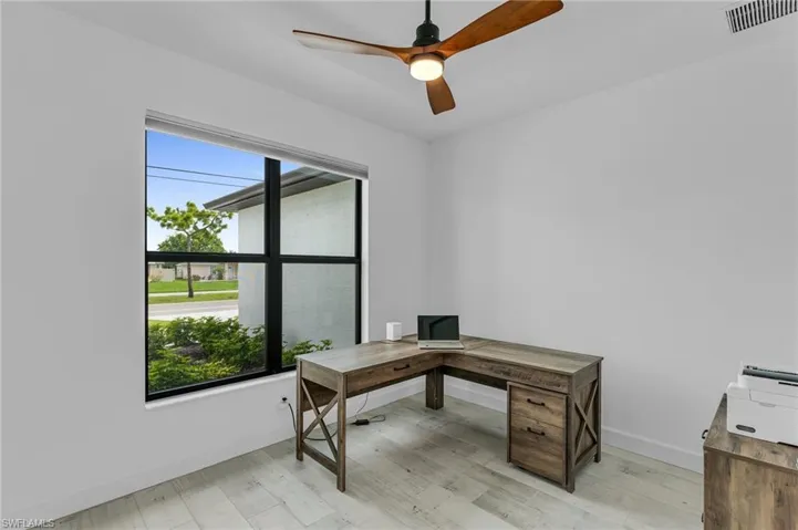 Office space with light hardwood / wood-style flooring and ceiling fan