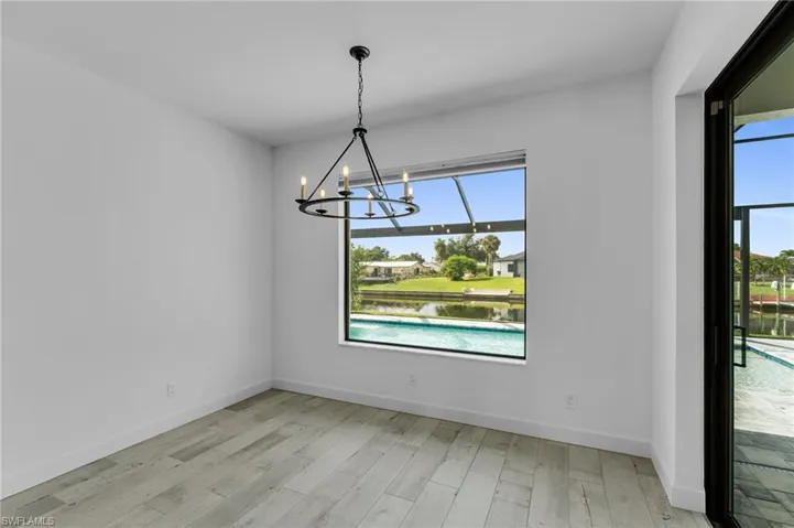 Unfurnished dining area with light hardwood / wood-style floors and a notable chandelier