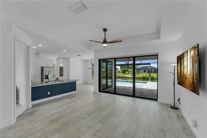 Unfurnished living room featuring sink, light hardwood / wood-style flooring, and ceiling fan
